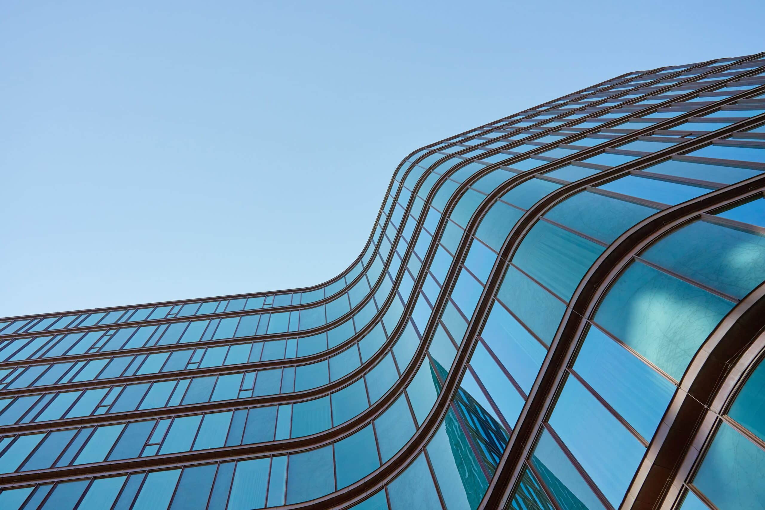 Modern,Building,With,Curved,Glass,Facade,Reflecting,Sky &ndash; Ecora